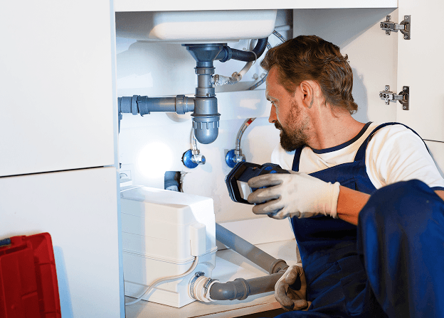 Plumber working under kitchen sink